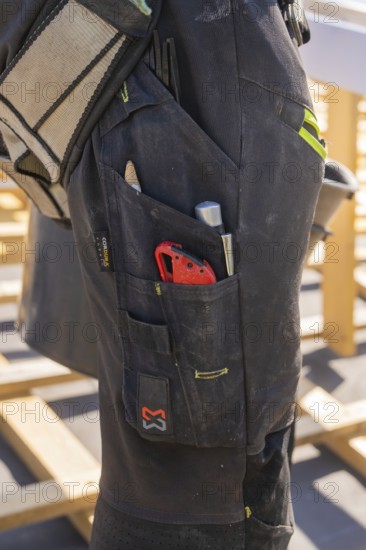 Tools in the pocket of a construction worker's black work trousers, roof renovation, house construction, Pforzheim, Germany