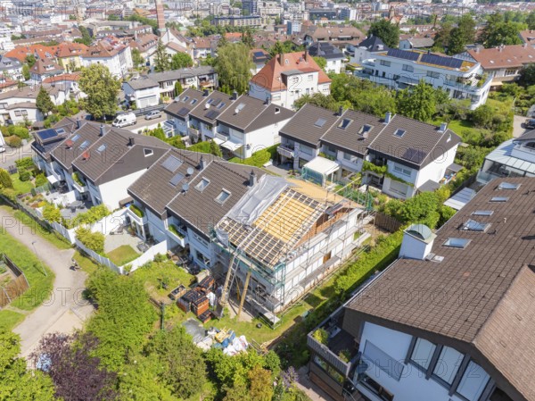 Overview of a city. A house stands in the middle of renovation of the roof in a residential neighbourhood, roof renovation, house construction, Pforzheim, Germany