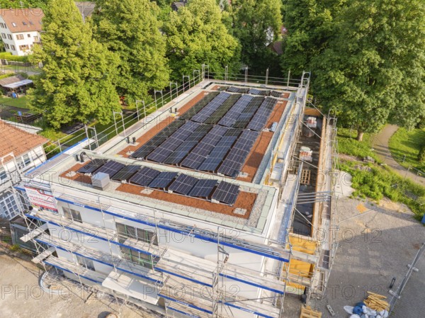 Construction site with solar panels on the roof, surrounded by trees and village houses, Hirsau, Calw, Germany