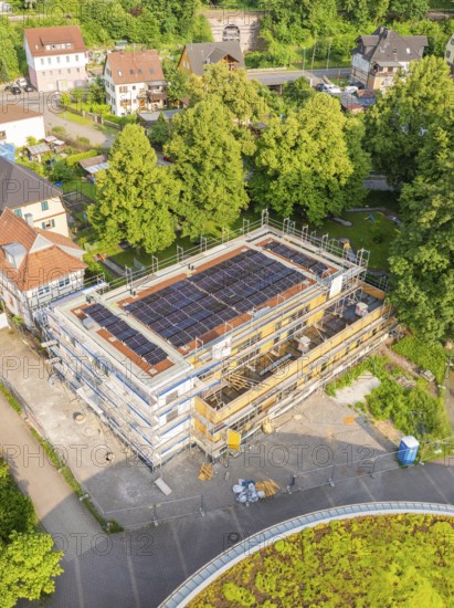 Building with solar panels on the roof, construction site in a village setting, surrounded by trees, Hirsau, Calw, Germany