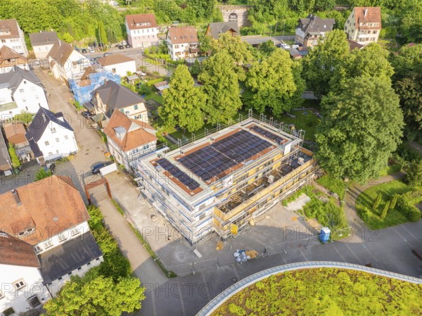 Aerial view of a construction site with solar panels, surrounded by village architecture and greenery, Hirsau, Calw, Germany