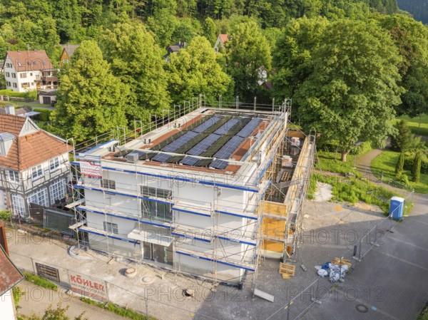 Multi-storey building with solar panels in a green environment, construction site in the foreground, Hirsau, Calw, Germany