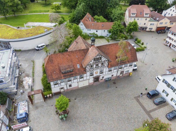 Historic half-timbered building with red roof, surrounded by cobbled streets and greenery, Hirsau, Calw, Germany