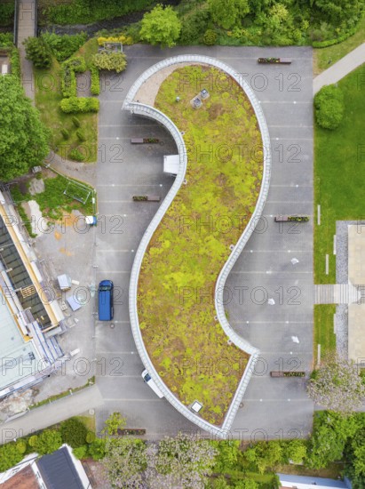 Building with curved green roof, surrounded by a car park and green areas, Hirsau, Calw, Germany