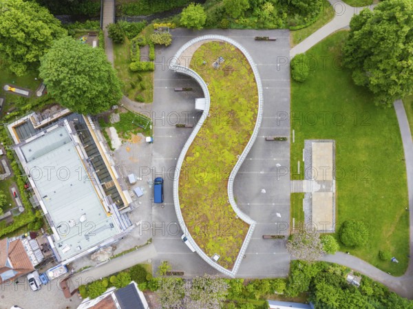 Aerial view of a building with a curved green roof and surrounding car park, Hirsau, Calw, Germany