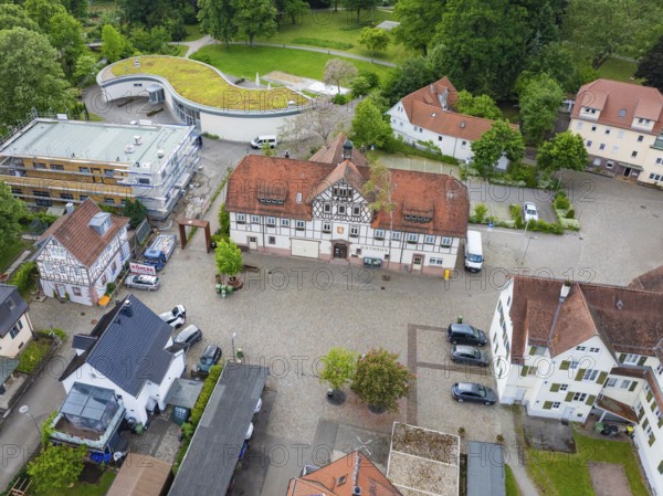 Historic half-timbered houses with red tiled roofs surrounded by cobblestones and green spaces, Hirsau, Calw, Germany