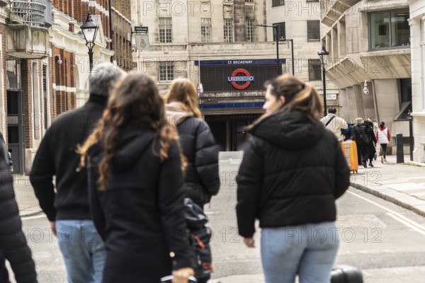 Tourists walking on a london street towards st. Paul's tube station, a major transportation hub in the city