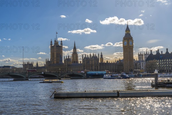Westminster palace with big ben and westminster bridge over river thames under a blue sky in london, uk