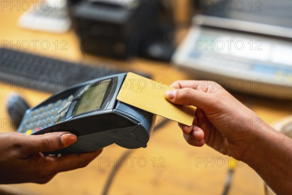 Customer making a purchase using a credit card on a point of sale terminal, highlighting modern payment technology in a retail environment