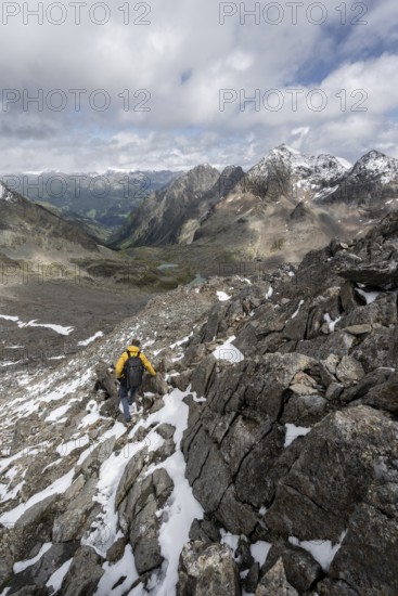 Mountaineer in rocky mountain landscape, at the summit of Keeskopf, behind summit of Petzeck, Hoher Perschitzkopf and Kruckelkopf, Schober group, Hohe Tauern National Park, Carinthia, Austria