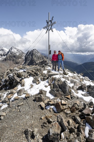 Two female mountaineers on the summit of the Keeskopf with summit cross, behind them summit of the Petzeck, Hoher Perschitzkopf and Kruckelkopf, Schober group, Hohe Tauern National Park, Carinthia, Austria