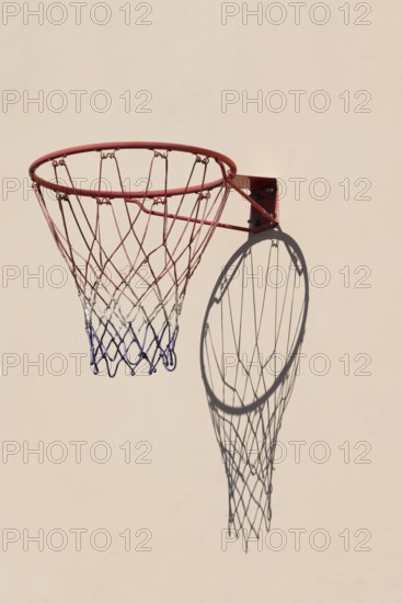 Basketball hoop with shadow cast on a white wall