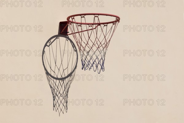 Basketball hoop with shadow cast on a white wall