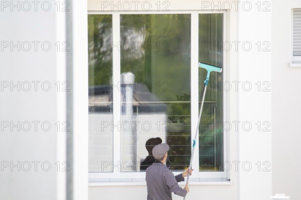 Building cleaner cleans the windows of a new residential building