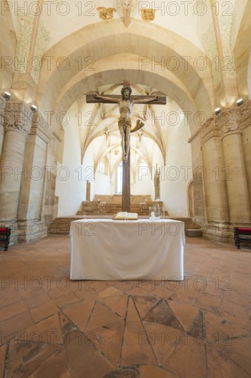 Altar with crucifix in a sacred room with stone arches, event and wedding location Lorch Monastery, Lorch, Germany