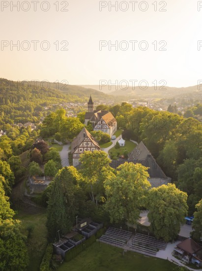 Aerial view of a village with a church surrounded by greenery at sunset, event and wedding location Lorch Monastery, Lorch, Germany