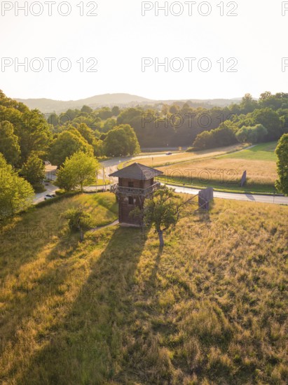 A wooden tower in a grassy landscape with long shadows and soft evening light, event and wedding location Lorch Monastery, Lorch, Germany