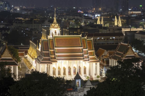 Panorama after sunset from Golden Mount to Wat Ratchanatdaram Worawihan and the Democracy Monument in the background on the right, skyline of Bangkok, Thailand