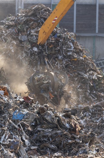 Hydraulic crane lifts scrap metal at the scrap yard