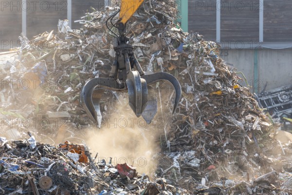 Hydraulic crane lifts scrap metal at the scrap yard