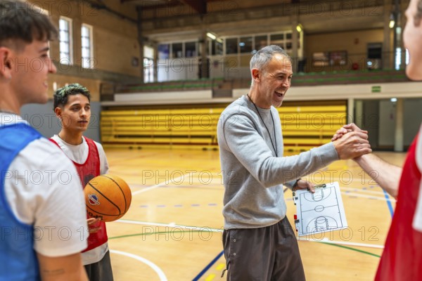 Basketball coach shaking hands with a player and congratulating him after a training session in a gym