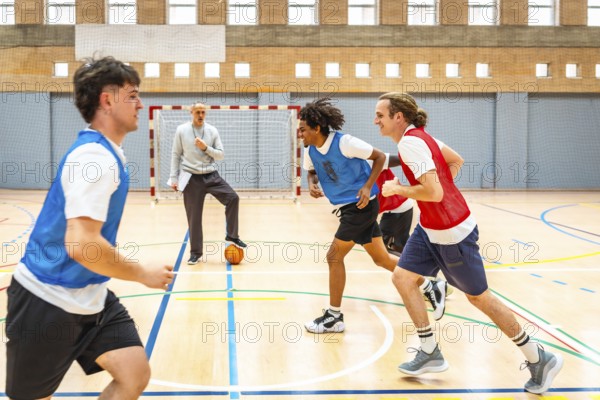 Group of young basketball players running on the court during practice, with their coach watching and guiding them