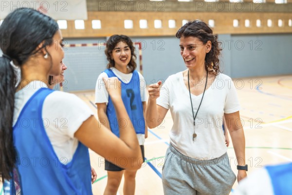 Female basketball coach motivating her team during training, encouraging players and giving support on the court