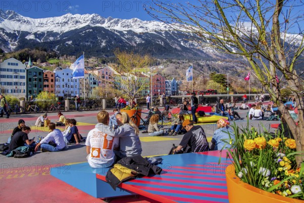 Sun-seekers on the market square on the banks of the Inn in front of the Nordkette mountain range of the Karwendel Mountains, Innsbruck, Inntal, Tyrolean Alps, Tyrol, Austria