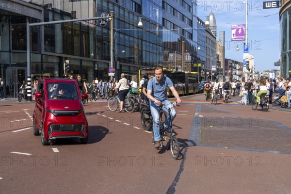 Central cycle path along the Vredenburg, in the city centre of Utrecht, lanes for pedestrians, cyclists and local traffic are separated, heavy traffic, no car/truck traffic, mini car, moped car, Utrecht, Netherlands