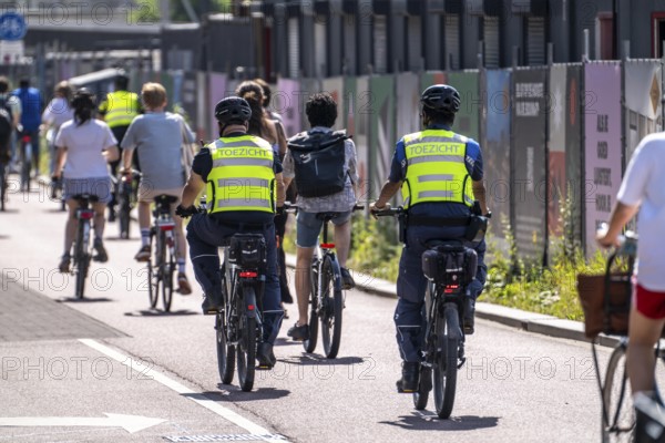 Central cycle path on the Vredenburg, in the city centre of Utrecht, lanes for pedestrians, cyclists and local traffic are separated, heavy traffic, no car/truck traffic, employees of the public order office, Toezicht en handhaving, on cycle patrol, Utrecht, Netherlands