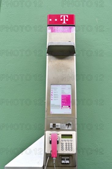 Public telephone on a green wall, Wismar, Mecklenburg-Vorpommern, Germany