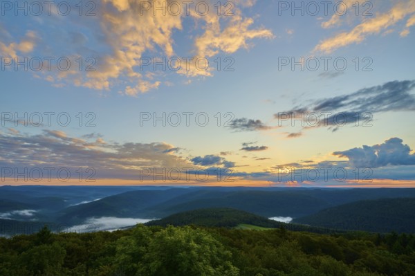Sunrise with dramatic clouds behind wooded hills, golden light in the sky, Katzenbuckel, Waldbrunn, Neckar-Odenwald-Kreis, Odenwald, Baden-Württemberg, Germany