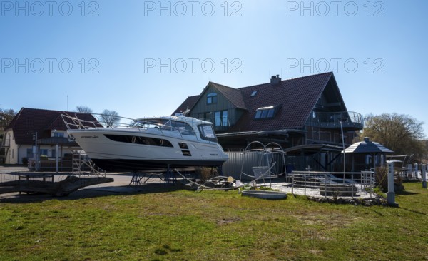 Motor yacht on a slag heap, Neuensiener See jetty in Seedorf, Rügen, Mecklenburg-Western Pomerania, Germany