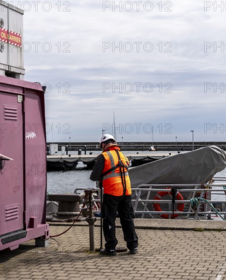 Worker with safety waistcoat in the city harbour of Sassnitz, Rügen, Mecklenburg-Vorpommern, Germany