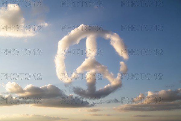 A naturally formed peace sign made of white clouds floats in a clear blue sky, symbolizing harmony and hope. Generative ai, AI generated
