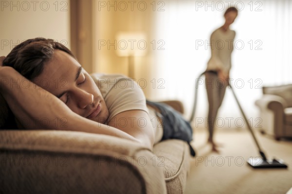 Close up of man resting on couch while woman cleans. Mental load and gender imbalance at home. Generative Ai, AI generated