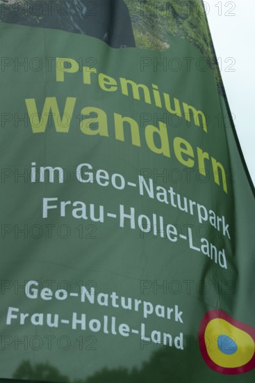 Premium hiking trail, GEO nature park Park Frau Holle Land am Meissner, low mountain range, legendary figure, home of the fairy tale, inscription on flag Kassel district, Fulda Werra Bergland, Germany