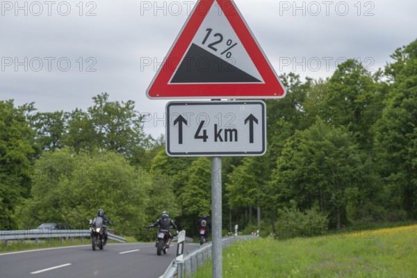 Road sign Gradient, gradient 12 per cent, length 4km, GEO nature park Park Frau Holle Land am Meissner, low mountain range, legendary figure, home of the fairy tale, motorcyclist, country road, crash barriers, forest, Kassel district, Fulda Werra Bergland, Germany