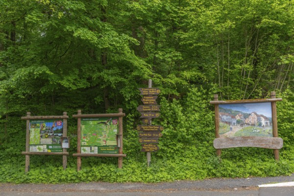 Signposts with directions for hiking trails and premium trails, GEO nature park Park Frau Holle Land am Meissner, low mountain range, legendary figure, home of the fairy tale, maps for orientation, painting of the mining village of Schwalbenthal from 1880, Kassel district, Fulda Werra Bergland, Germany