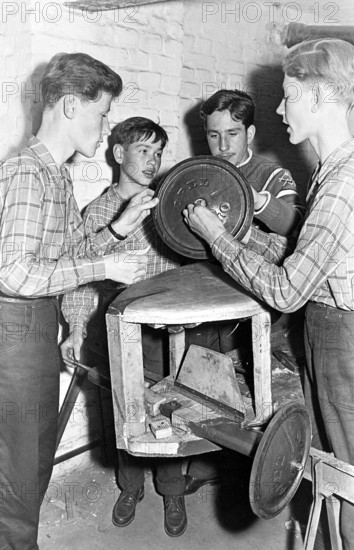 Young men craftsmen, 1950s, Group of young men working with technical equipment in a workshop, Historical photo