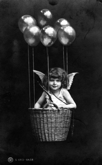 Cupid floating in basket with balloons, girl as angel in basket with balloons and wings, imaginative depiction, historical photo