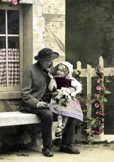 Costume, traditional dress, man and child in historical dress sitting on a bench outdoors, historical photo