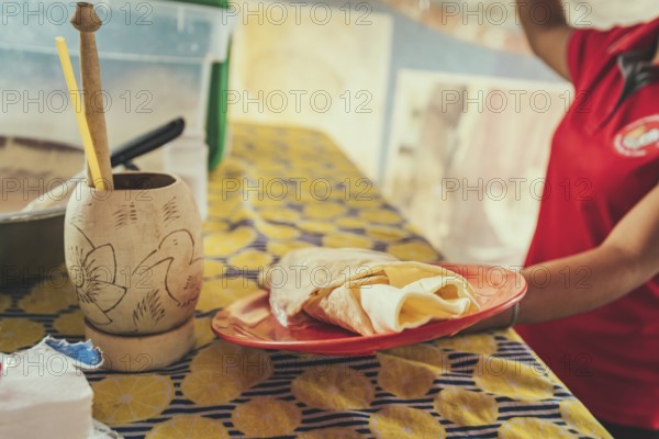 Vendor serving traditional quesillo on a plate. Hands of a person serving traditional quesillo