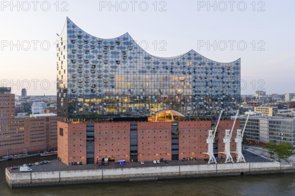 The Elbphilharmonie concert hall in Hamburg is reflected in the glass design above the historic Kaispeicher warehouse, Hamburg, Germany