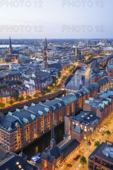 Aerial view of the Speicherstadt Hamburg at blue hour with churches and Alster in the background, Hamburg, Germany