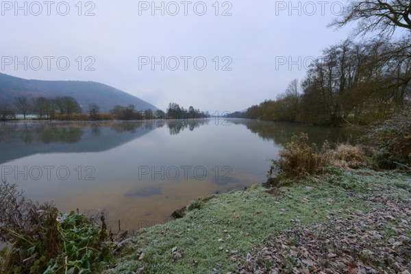 A calm winter river, with frozen banks and bare trees in the background, Laudenbach, Main, Spessart, Odenwald, Bavaria Germany