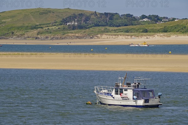 Motorboat on calm water near a green coast with hills in the background, Camel Trail, Padstow, Cornwall, Cornwall, England, United Kingdom