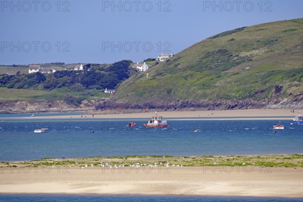 Coastal landscape with boats on blue water and green wooded hills, Padstow, Cornwall, Cornwall, England, United Kingdom