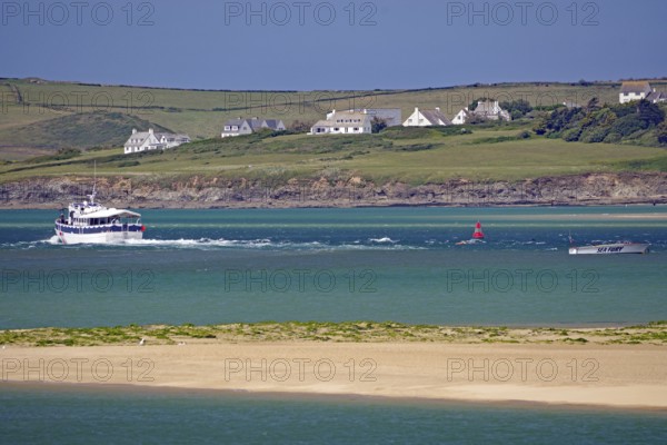 Boats and houses along a green coast with hills and blue water, Padstow, Cornwall, Cornwall, England, United Kingdom