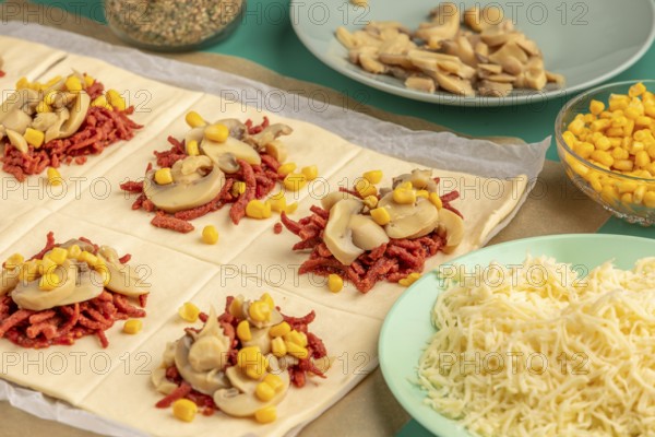 Sliced dough squares with tomato paste, bacon, mushrooms and sweetcorn alongside other ingredients for pizza, balls